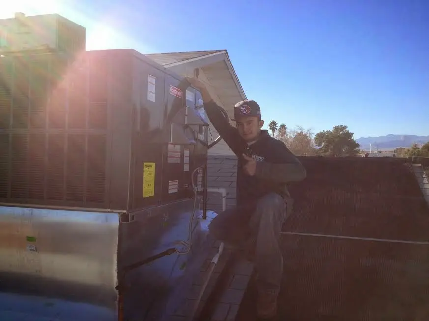 HVAC technician performing Air Duct Cleaning on a rooftop unit in Lehman